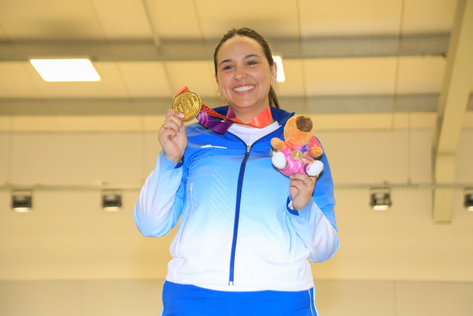 Fernanda Russo con la medalla de oro y la mascota de los Juegos Suramericanos Santa Fe 2026.
