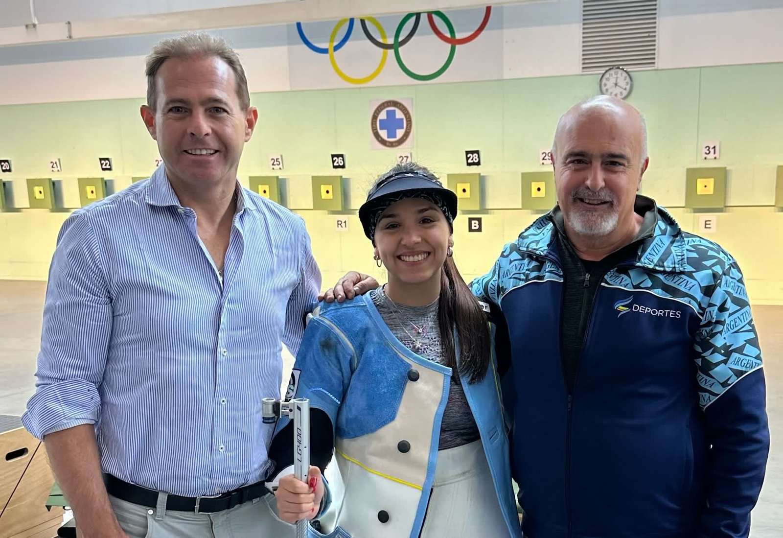 Fernanda Russo junto al Dr. José Arrieta y su entrenador en el Tiro Federal Argentino, octubre de 2023.
