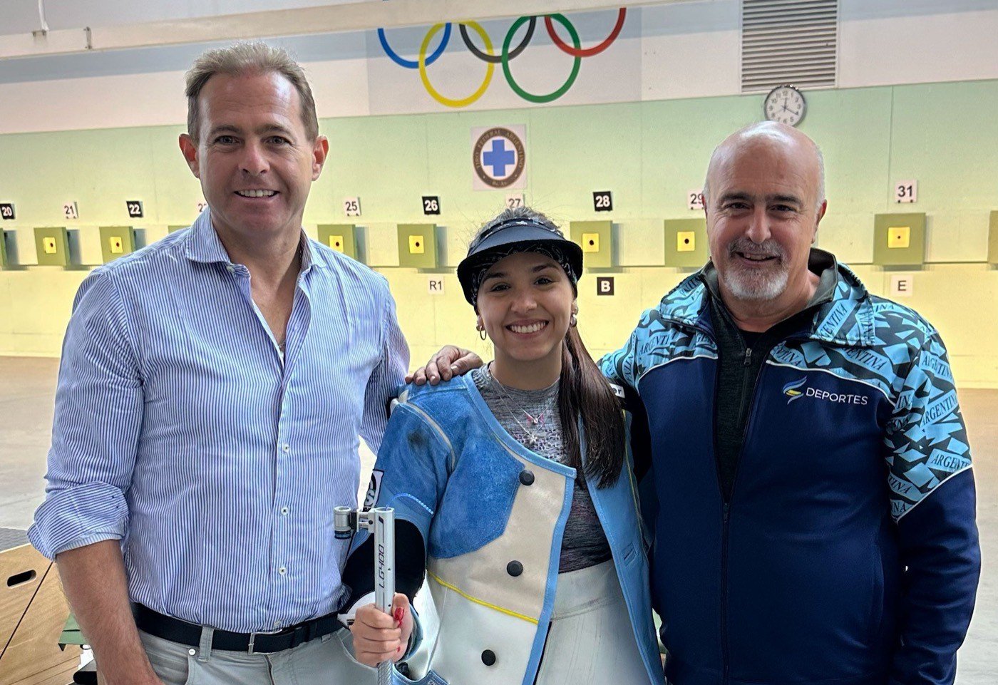Fernanda Russo junto al Dr. José Arrieta en el polígono de tiro, bajo los aros olímpicos.
