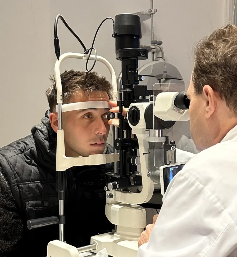 El Dr. José Arrieta examinando a un deportista en la lámpara de hendidura.